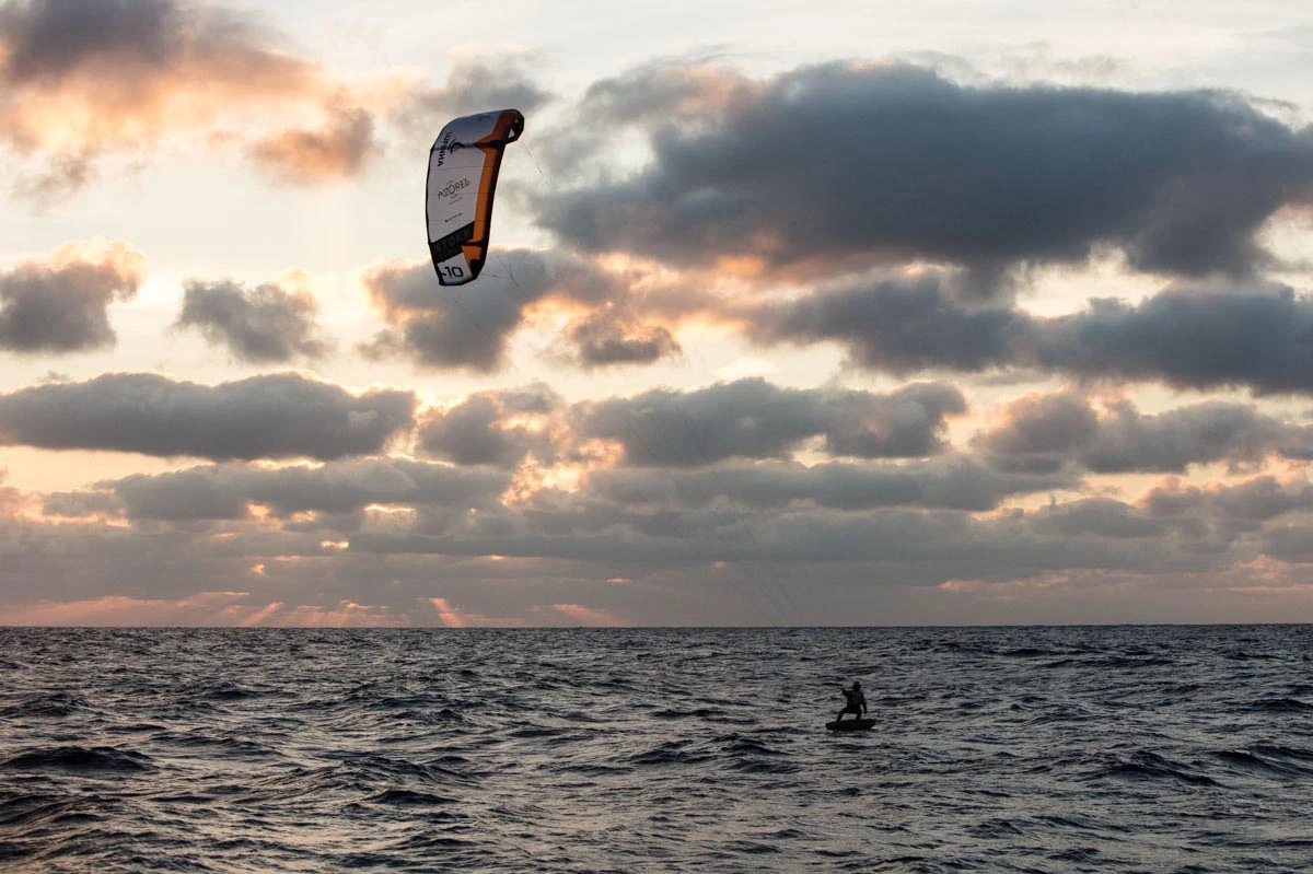 Francisco Lufinha naviguant seul en mer au soleil couchant, sous un ciel rose et nuageux, lors de sa traversée vers Madère